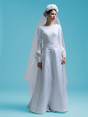 Image showing beautiful woman wearing wedding dress against cyan background