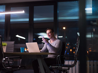 Image showing man working on laptop in dark office