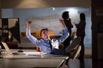 Image showing businessman sitting with legs on desk at office