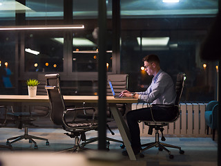 Image showing man working on laptop in dark office