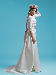 Image showing beautiful woman wearing wedding dress against cyan background