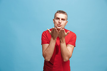 Image showing Portrait of attractive man with kiss isolated over blue background