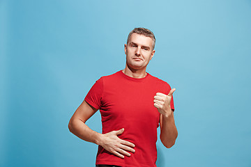 Image showing The happy businessman standing and smiling against blue background.