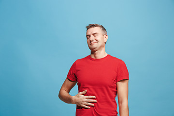 Image showing The happy businessman standing and smiling against blue background.