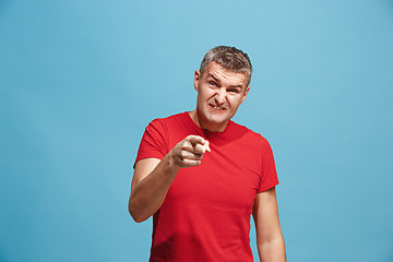 Image showing The serious business man pointing to camera, half length closeup portrait on blue background.