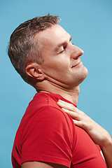 Image showing The happy businessman standing and smiling against blue background.