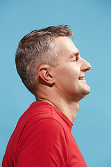 Image showing The happy business man standing and smiling against blue background.