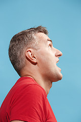 Image showing The young attractive man looking suprised isolated on blue