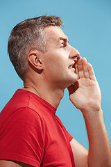 Image showing Isolated on pink young casual man shouting at studio