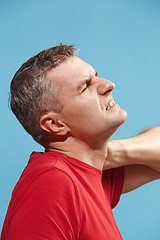 Image showing Young man overwhelmed with a pain in the neck .