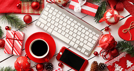 Image showing Christmas presents and decorations around gadgets and beverage