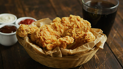 Image showing Fried chicken wings near sauces and drink