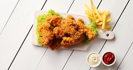 Image showing Sauces and French fries near lettuce and chicken wings