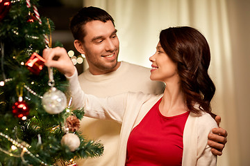 Image showing happy couple decorating christmas tree at home