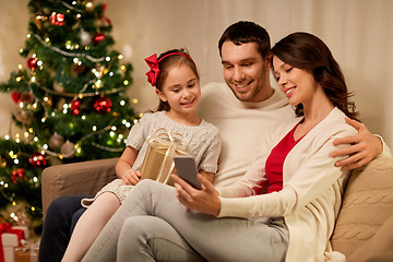 Image showing family with smartphone at home on christmas