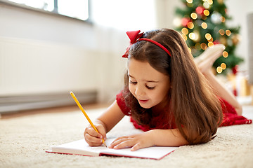 Image showing little girl writing christmas wish list at home