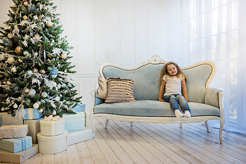 Image showing Beautiful girl sitting on the sofa near
