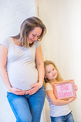 Image showing Beautiful pregnant woman standing near wall