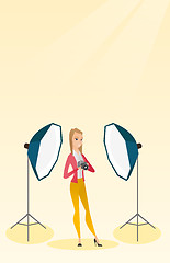 Image showing Photographer with a camera in a photo studio.