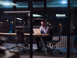 Image showing man working on laptop in dark office