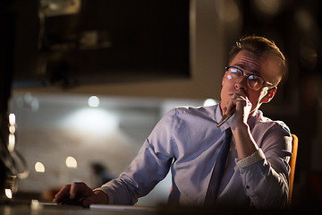 Image showing man working on computer in dark office