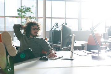 Image showing businessman sitting with legs on desk