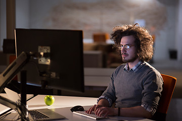 Image showing man working on computer in dark office