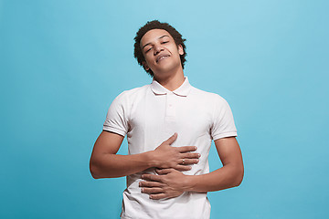 Image showing The happy business man standing and smiling against blue background.