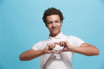 Image showing The happy business man standing and smiling against blue background.