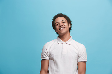 Image showing The happy business man standing and smiling against blue background.