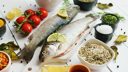 Image showing Spices and tomatoes around fish