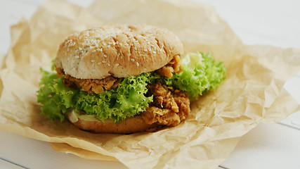 Image showing Chicken burger lying on parchment