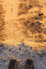 Image showing Feet of man standing on edge of sandstone cliff