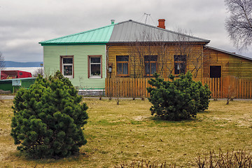 Image showing Old and new wooden house of two different colored halves