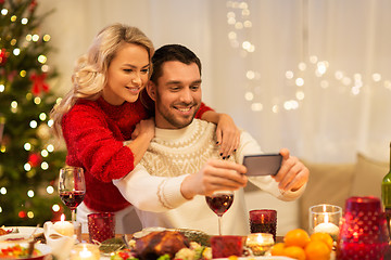 Image showing happy couple taking selfie at christmas dinner