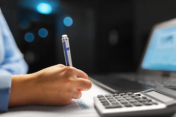 Image showing businesswoman with papers working at night office