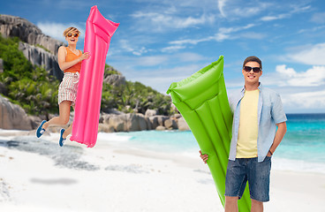 Image showing teenage girl jumping with float mattress on beach