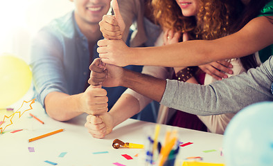 Image showing team making thumbs up hand sign at office party