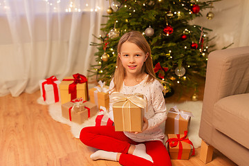 Image showing smiling girl with christmas gift at home