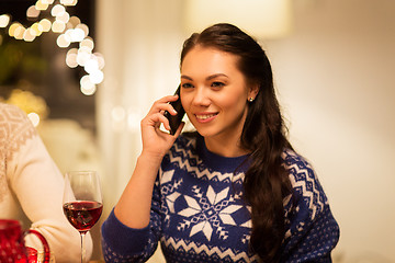 Image showing woman calling on smartphone at christmas dinner