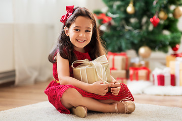 Image showing happy girl with christmas gift at home