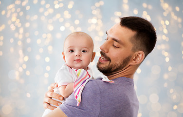 Image showing father with little baby girl over festive lights