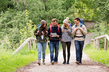 Image showing friends or travelers hiking with backpacks and map