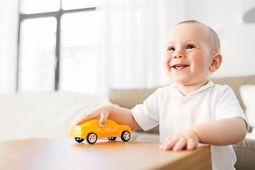 Image showing happy baby boy playing with toy car at home