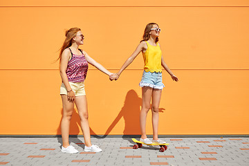 Image showing teenage girls riding skateboard on city street