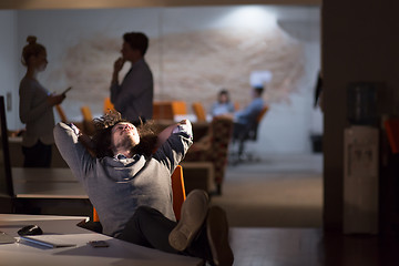 Image showing businessman sitting with legs on desk at office