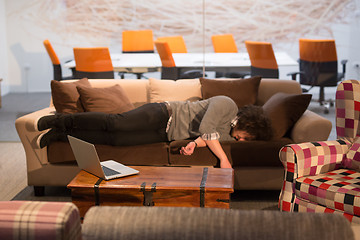 Image showing man sleeping on a sofa  in a creative office