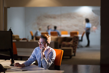 Image showing man using mobile phone in dark office