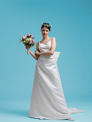 Image showing beautiful woman wearing wedding dress against cyan background