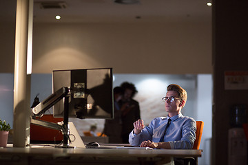 Image showing man working on computer in dark office